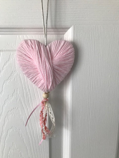 Wool heart hanging gift with lace and a bead. Perfect handmade unique gifts for the home in pink. Can be hung on a door or pinned to the wall.