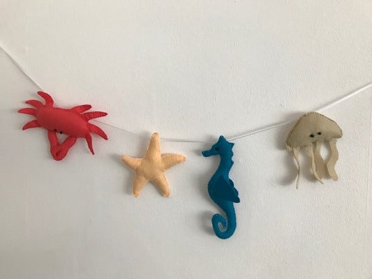 Handmade padded Felt Sea Creature Garland threaded on a ribbon string. This makes a perfect baby shower gift.  One seahorse, one crab, one starfish and one jelly fish all brightly coloured.