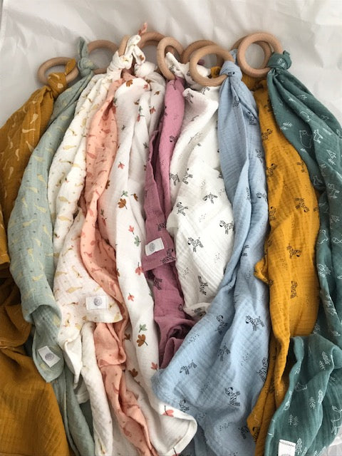 Selection of coloured muslin ‘Lovey’ cloth with beech teething ring. Available in zebra, geese, leaves or woodland animal print. Perfect for babies and toddlers to hold and for comfort.