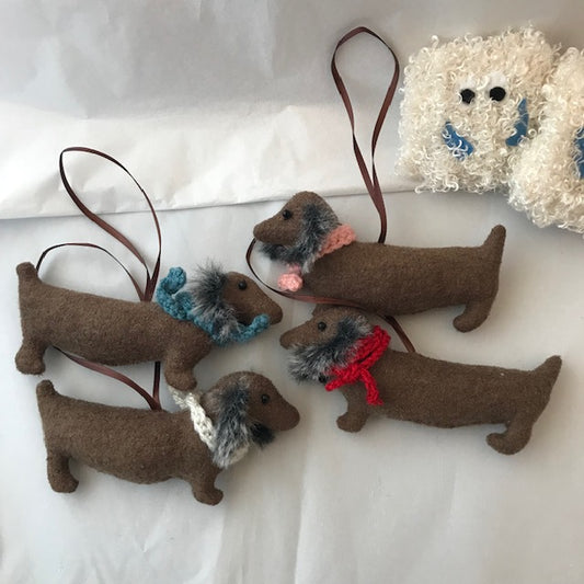 Four brown Dachshund Christmas Tree Decorations with long furry ears and a knitted wool scarf in pink, blue, red and white. Unique handmade Christmas Decor.